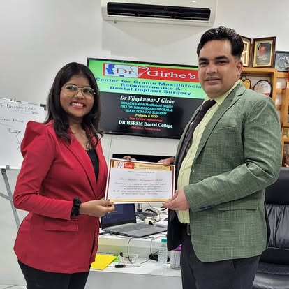Dr. Vijaykumar Girhe handing a training certificate to a dentist at the Center for Cranio-Maxillofacial, Reconstructive and Dental Implant Surgery